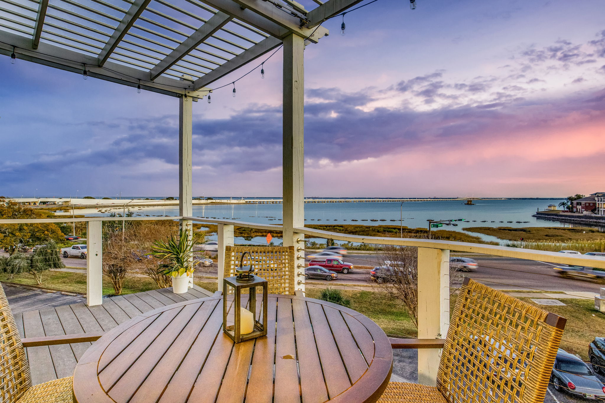 A view of Pensacola Bay from the vacation rental, Rainbow Row located in Downtown Pensacola. There is a table with two chairs on the balcony of the unit.