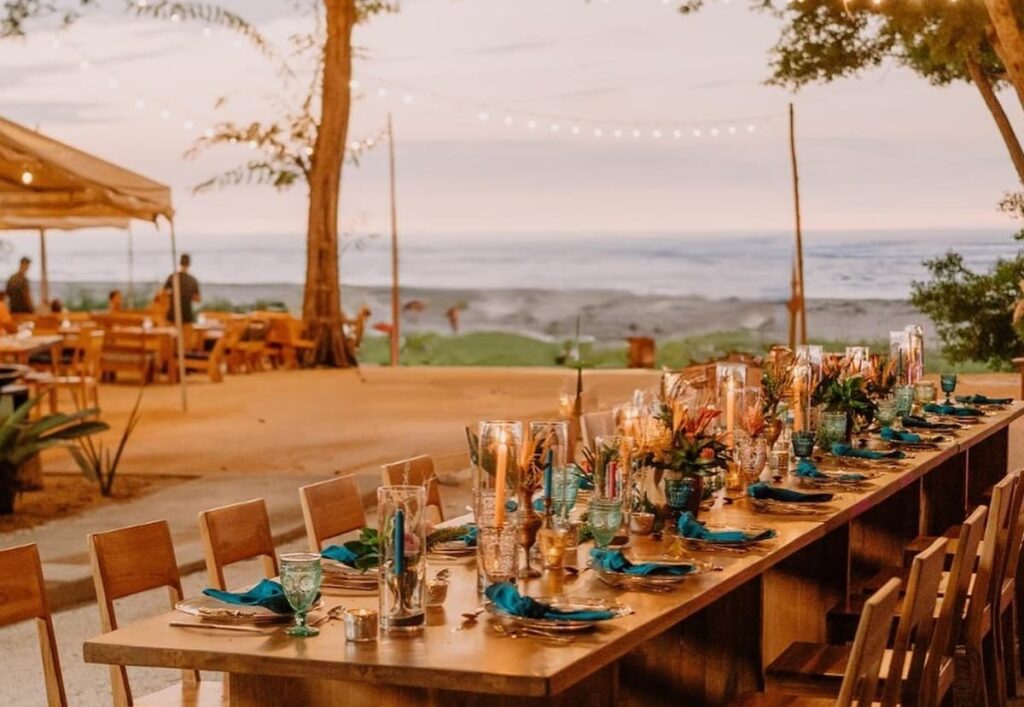 Table set up outdoors at the Pangas Beach Club overlooking the beach at sunset