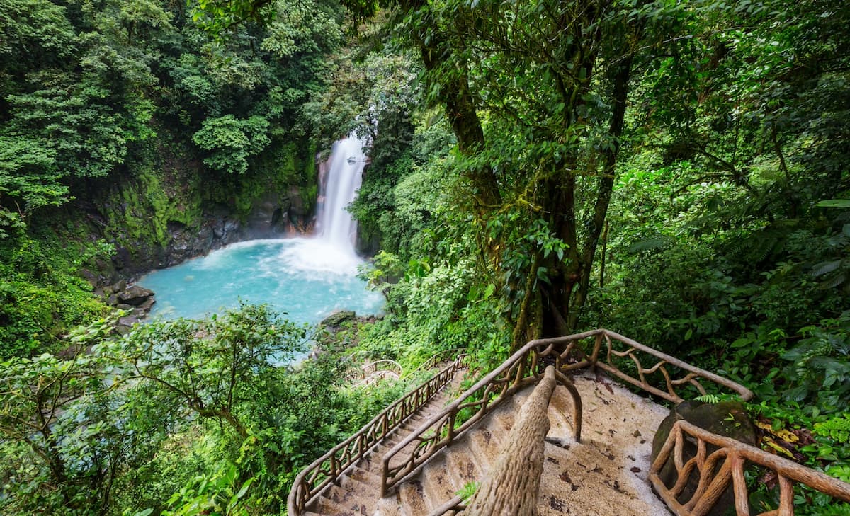 Hiking trail in Tamarindo Costa Rica with wooden steps leading down to a waterfall