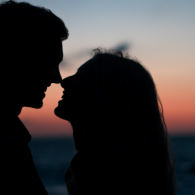 couples kissing with sun setting in background