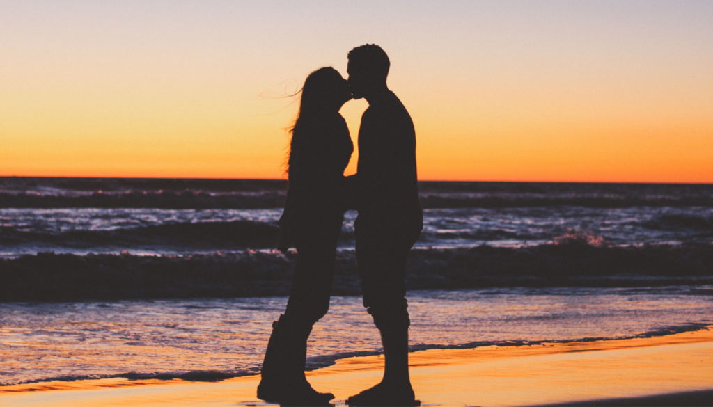 couple kissing on the beach at sunset