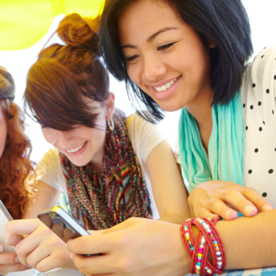 three young female adults looking at the scenic stays northwest florida travel guide on their phones