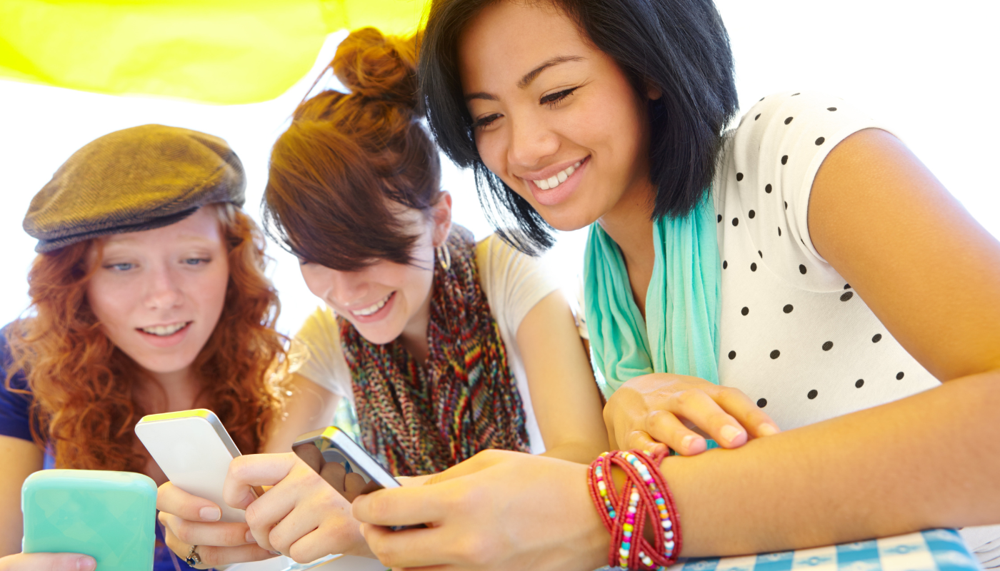 three female young adults looking at their northwest florida trip planning guide on their phone