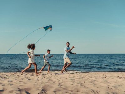family flying a kite on the beach