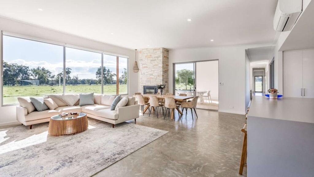 Busselton Hithergreen's bright and spacious open-plan living area with cream couch, dining set and rug