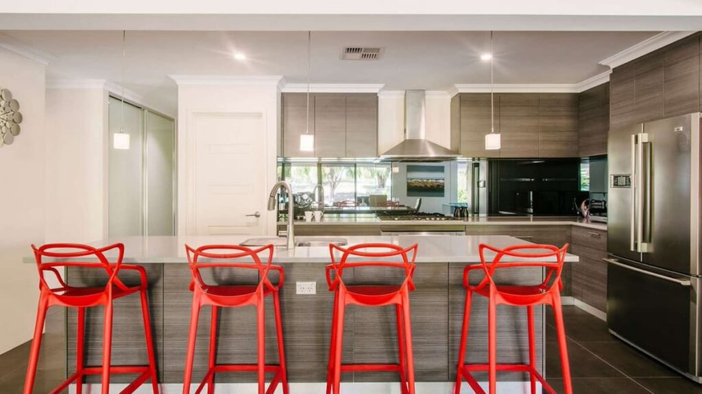 Fairways' modern kitchen with four red high stools at counter top