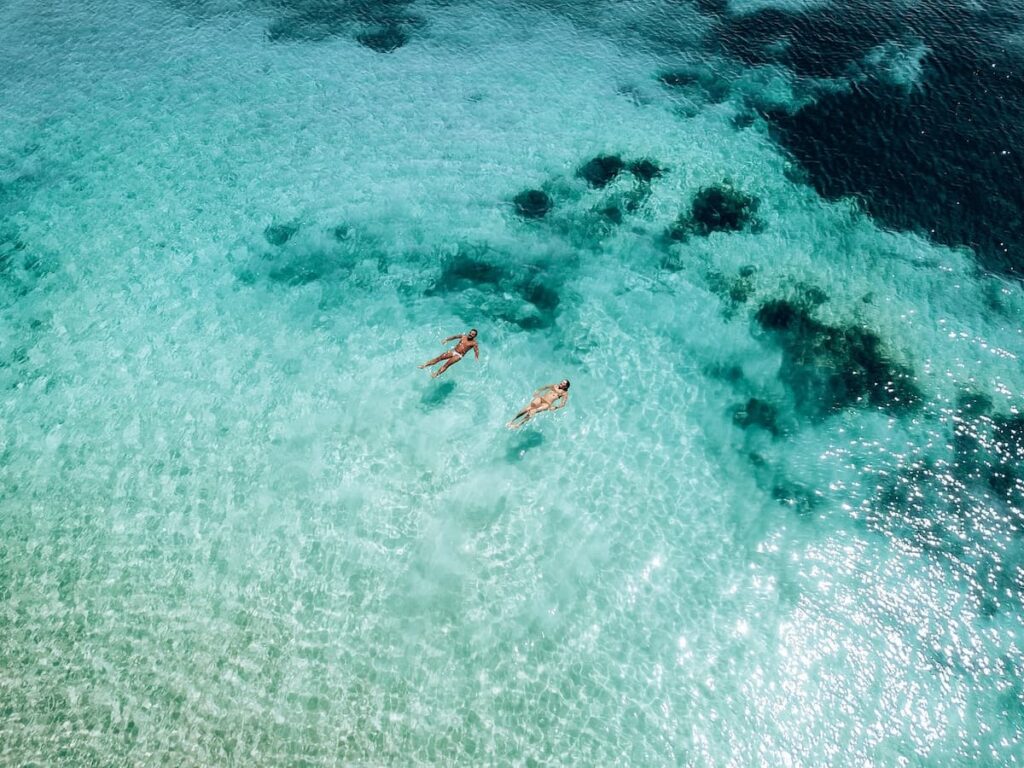 Two people floating in the clear blue waters in Yallingup WA