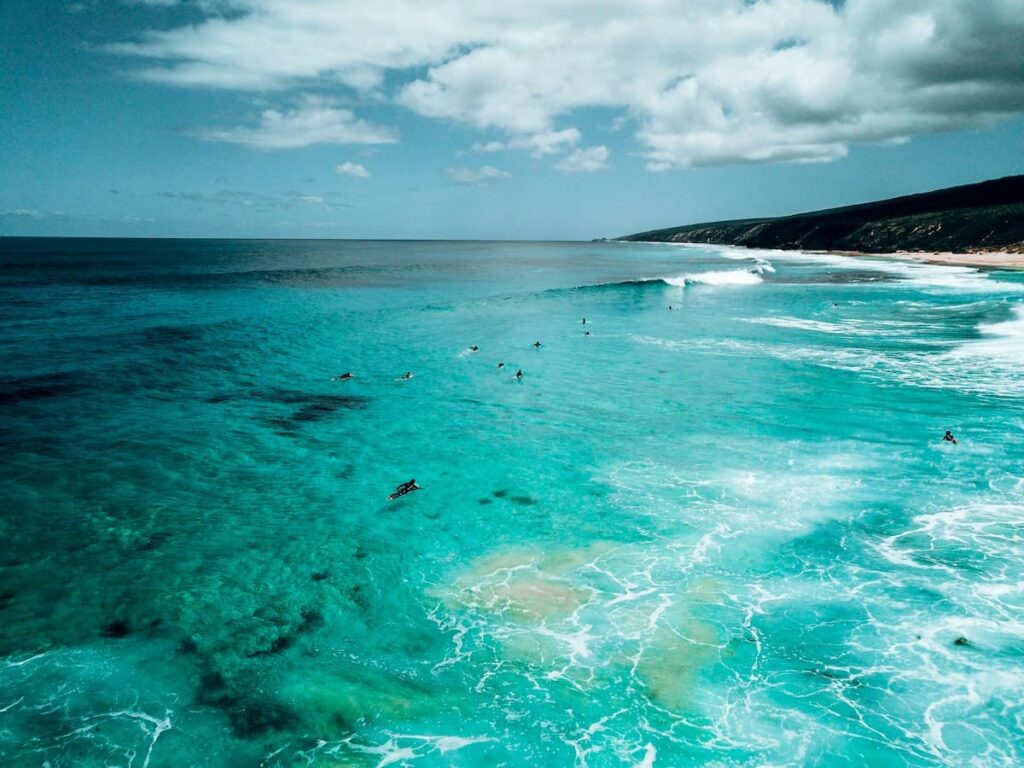 Surfers in the clear blue waters in Yallingup WA
