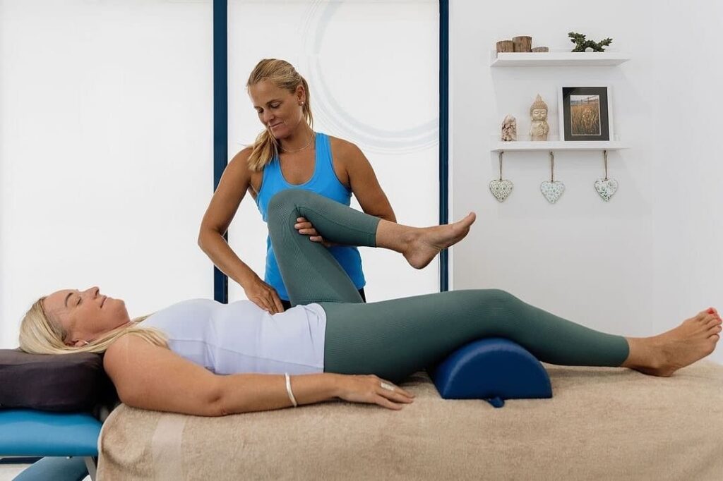 Woman performing Bowen therapy treatment on another woman in a spa-like setting in Dunsborough