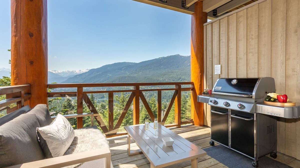 Outdoor decking with furniture and a BBQ overlooking mountain views