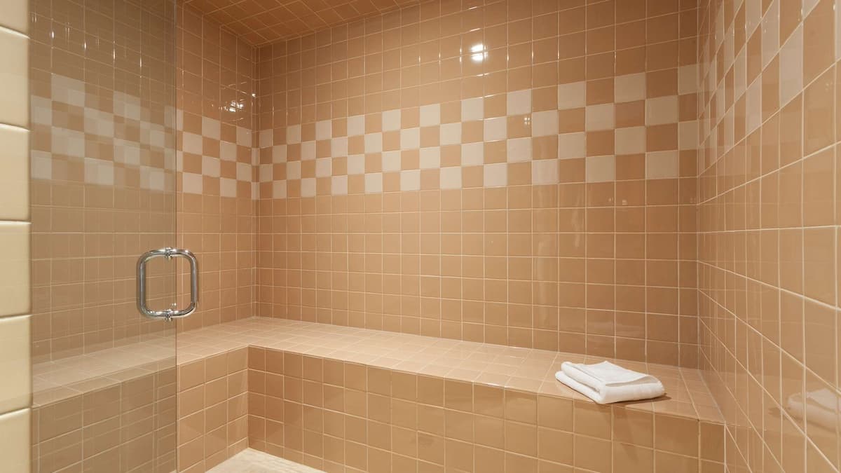 Steam room with cream colored tiles