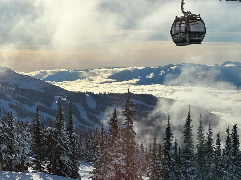 Snow-covered mountains and trees in Whistler with gondola above