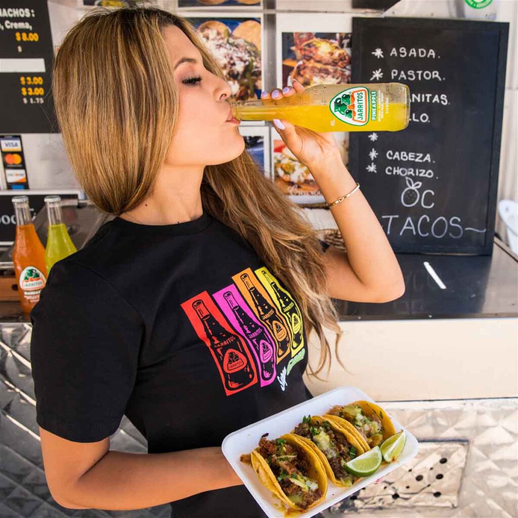 Woman eating and drinking from food cart