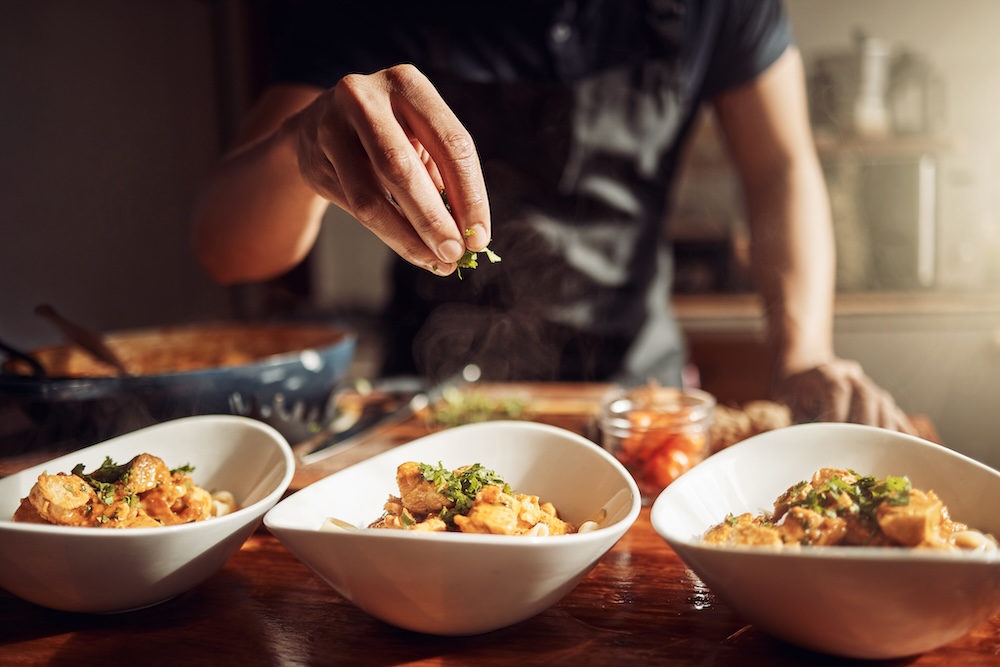 Private chef garnishing meal before serving