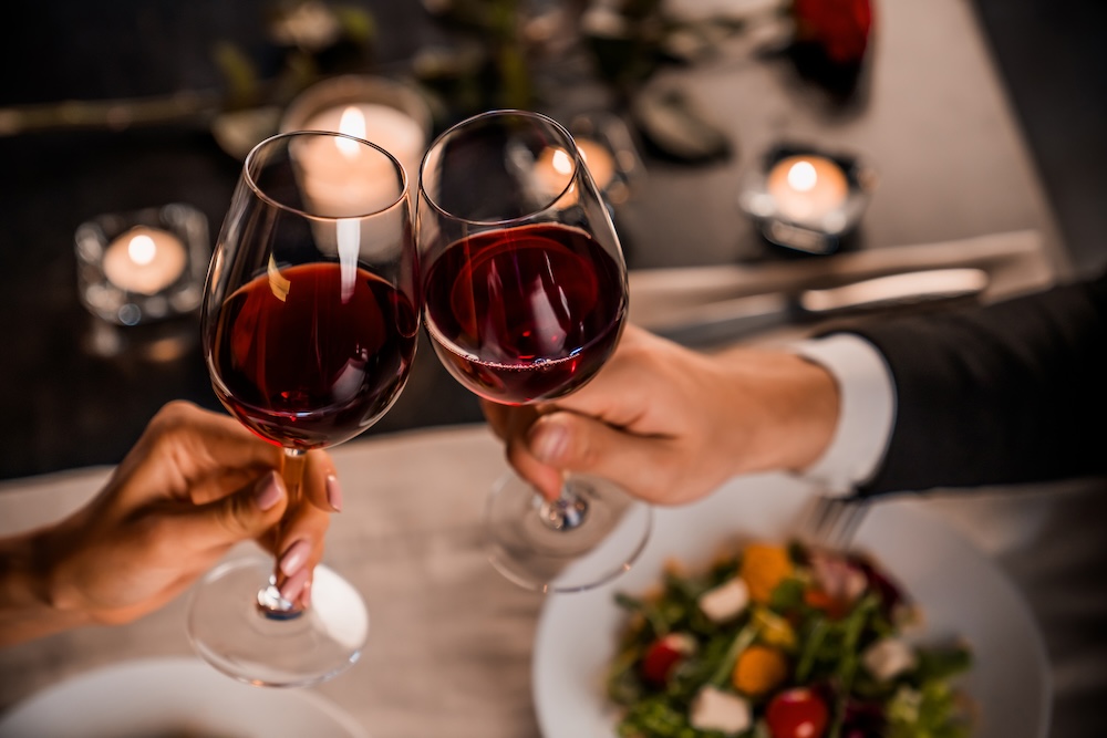 Couple toasting with glasses of red wine at a restaurant