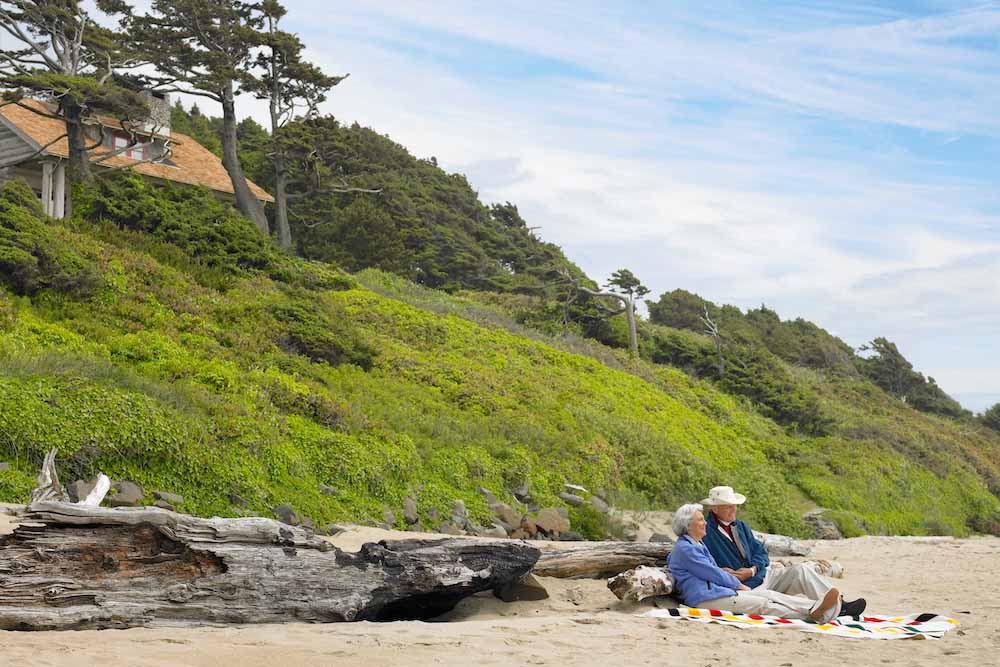 Couple on the beach sitting against some drywood