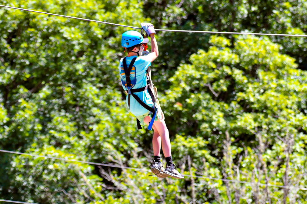 Picture of a young man ziplining on a zipline and canopy tour