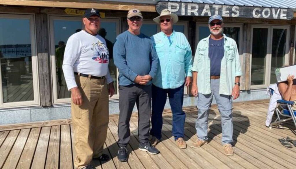 four men standing on fishing dock
