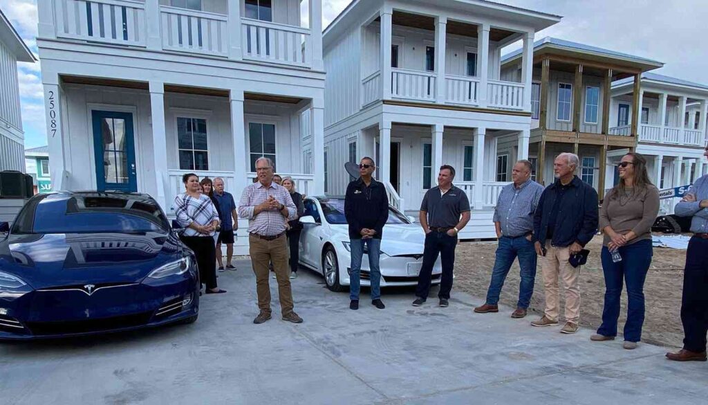 owner of kaiser vacation rentals surrounded by others in front of ocean edge vacation rental