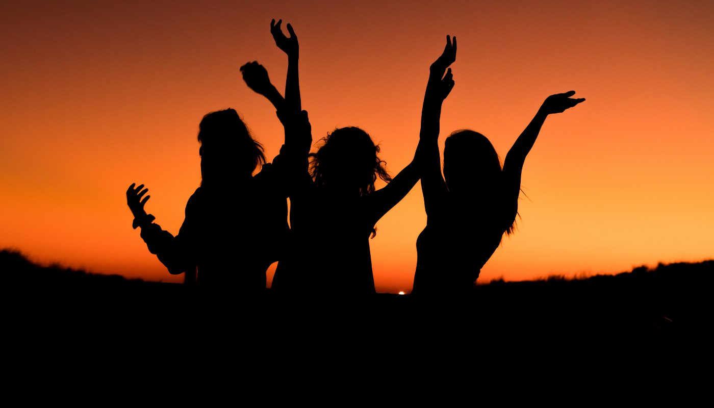 three girls on the beach at sunset celebrating a girls weekend in gulf shores