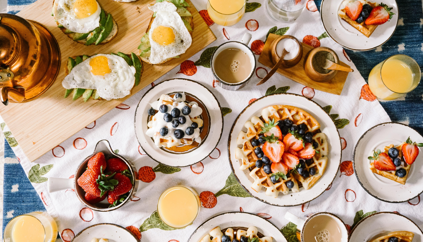 a series of breakfast items, including coffeee, waffles, avocado toast and fruit, prepared in a vacation rental