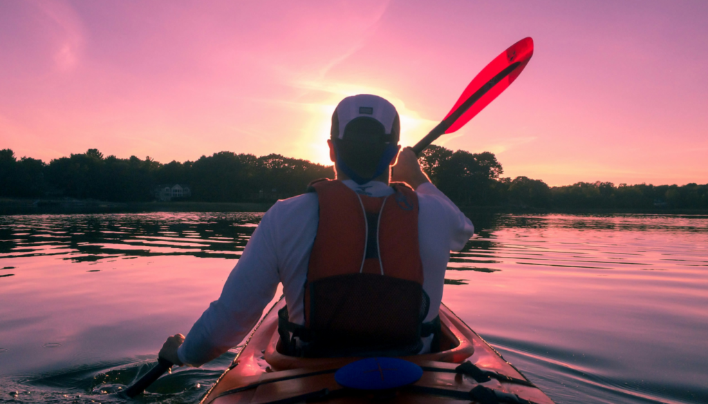 man kayaking in gulf shores during sunrise
