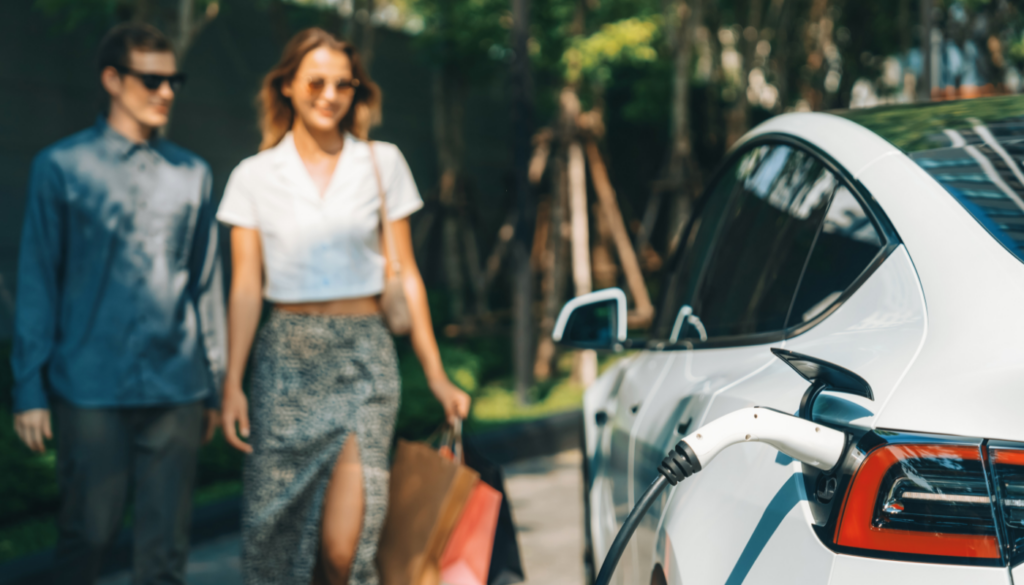 couple walking towards their electric vehicle while it's charging