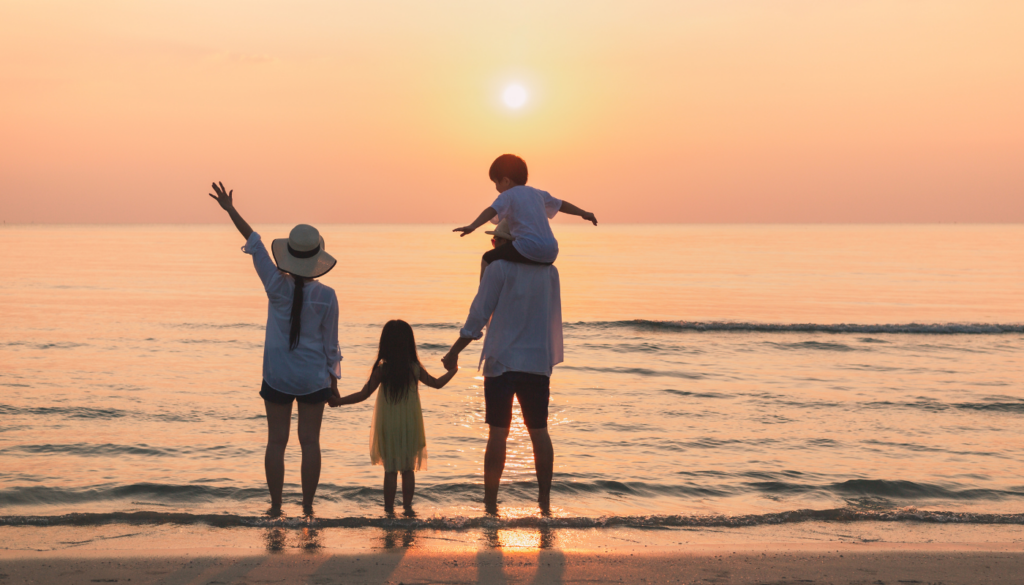 family watching the sunset on the beach in gulf shores, alabama