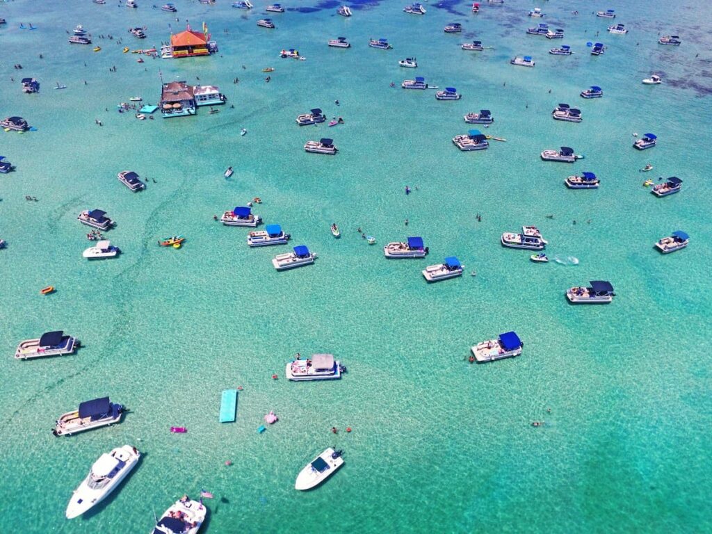 Multiple boats in the blue waters at Crab Island in Destin