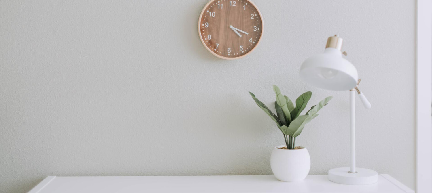 wall clock with desk lamp and plant