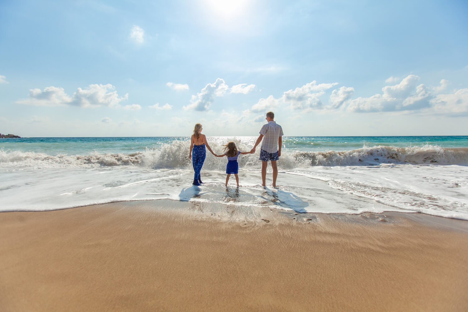 family getting wet on the beach