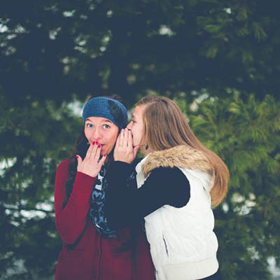 image of two women whispering