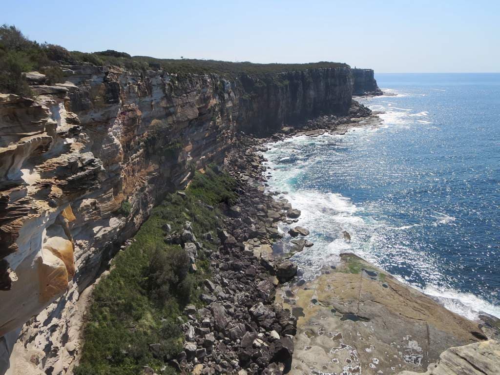 Large cliff face at North Head in Manly with ocean hitting against rock