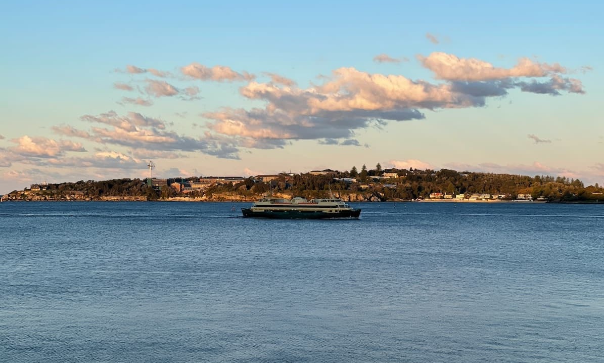 Ferry in waters beside Mosman with blue waters and clouds in the sky