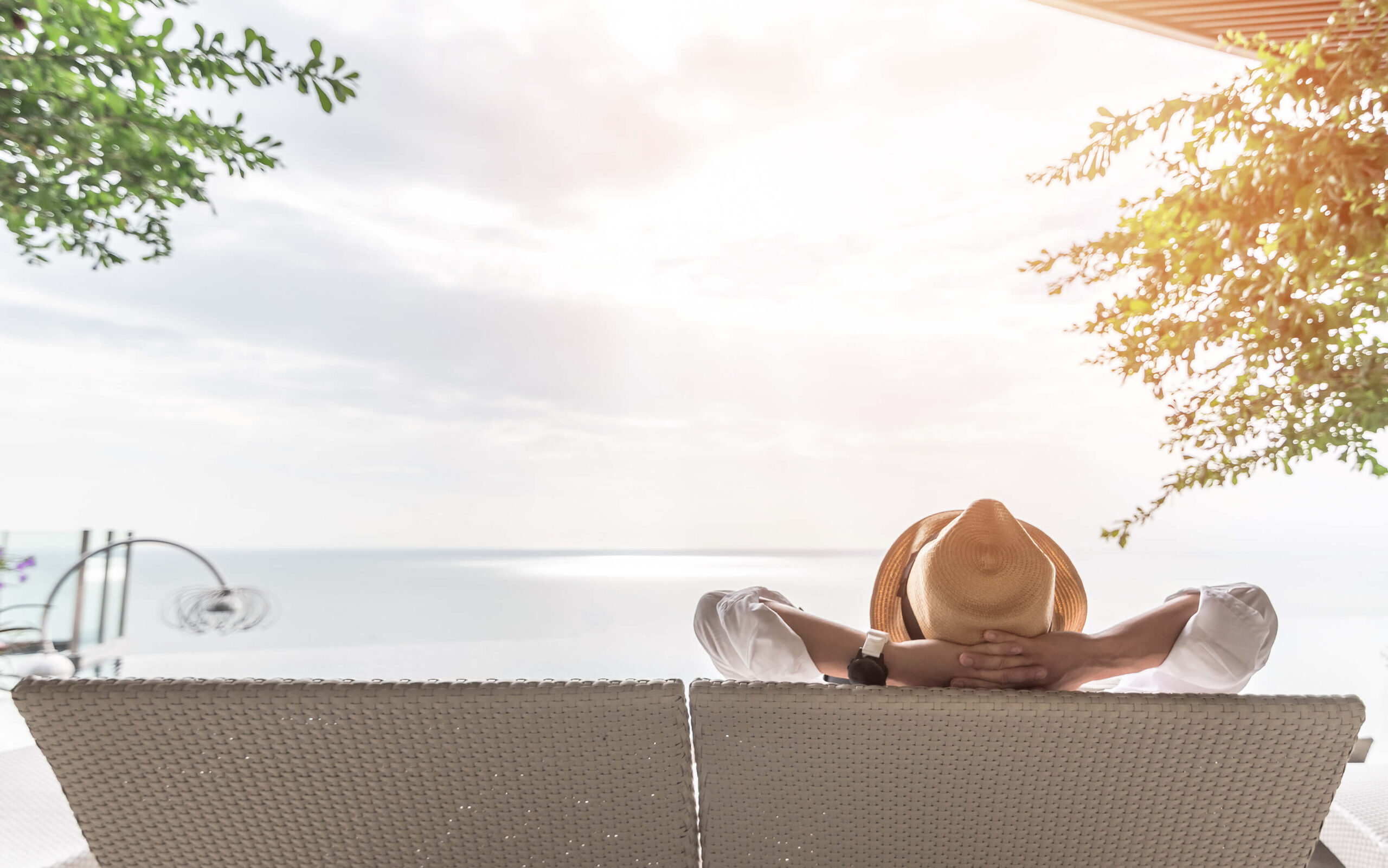 Person relaxing at a luxury seaside property, enjoying the benefits of international property investment