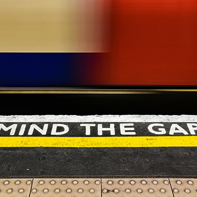 Mind the Gap sign at a train station, symbolizing careful attention to strata rules in NSW.