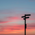 Silhouette of a directional sign at sunset, symbolising choices and changes in rental legislation.