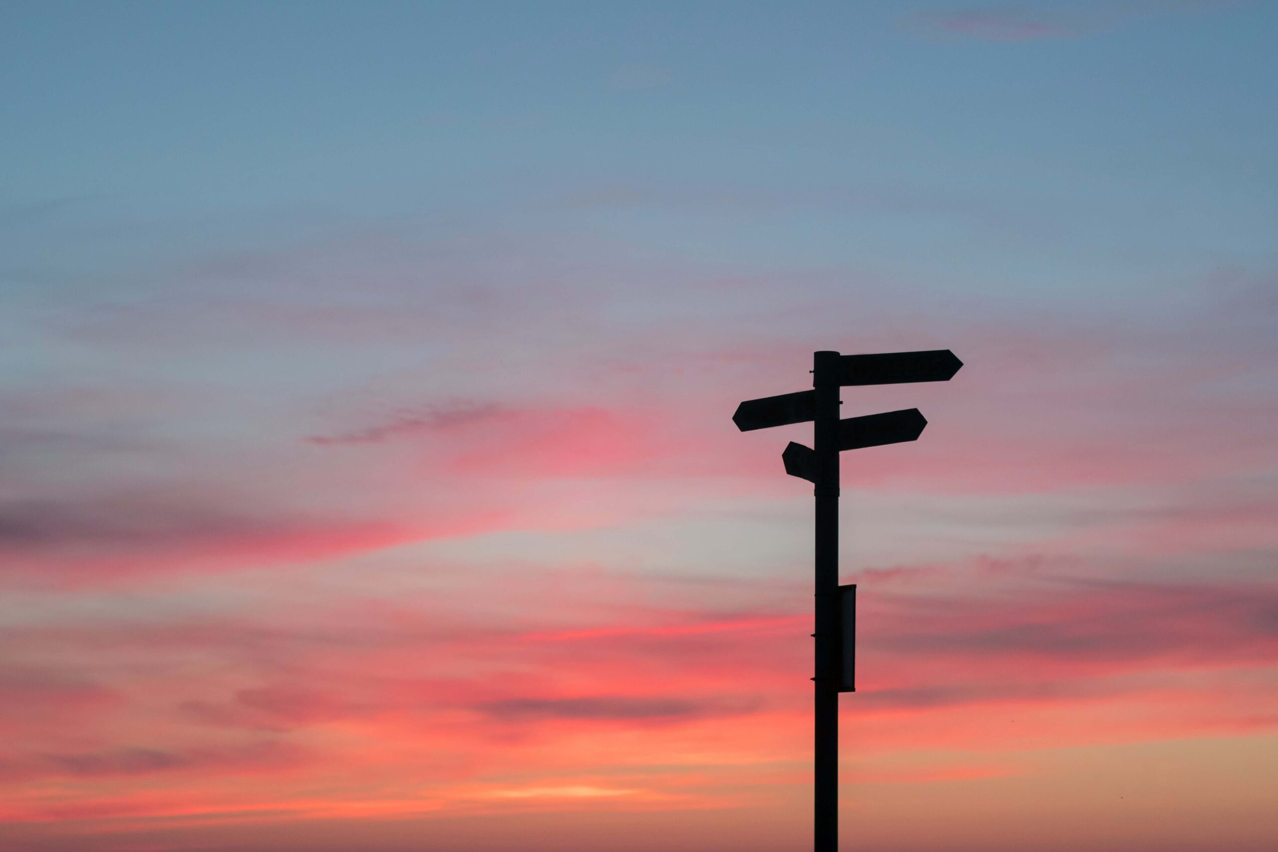 Silhouette of a directional sign at sunset, symbolising choices and changes in rental legislation.