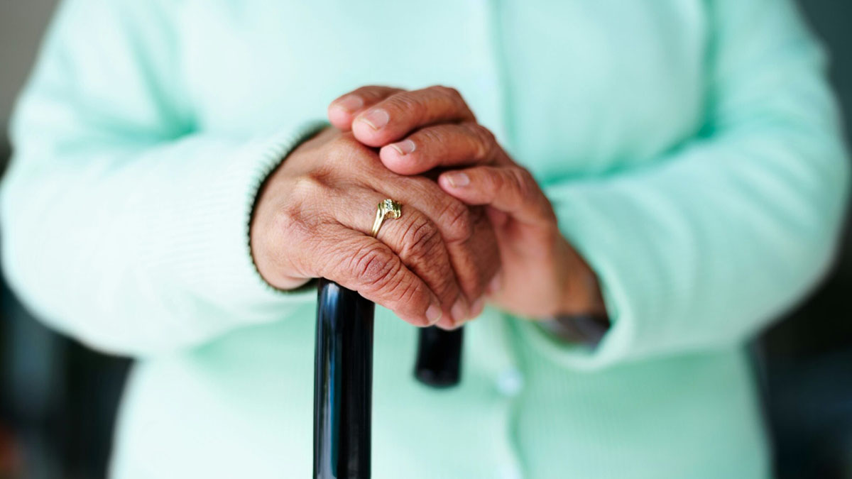 Photo of an elderly woman with a walking stick