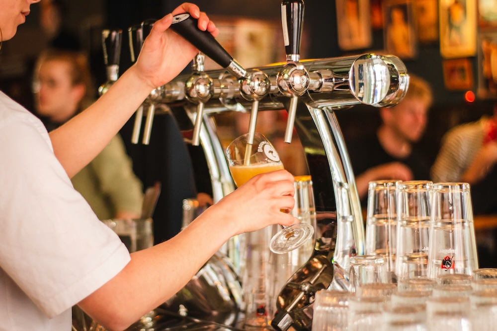 bartender pouring a draft beer at a craft brewery