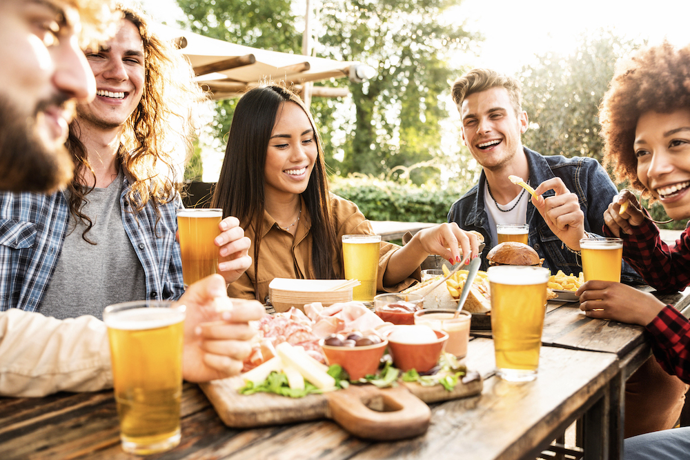 Group of friends having beers and dinner together at a brewery