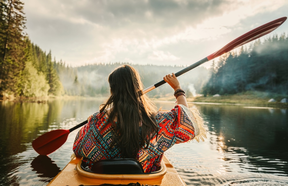 woman kayaking along a river