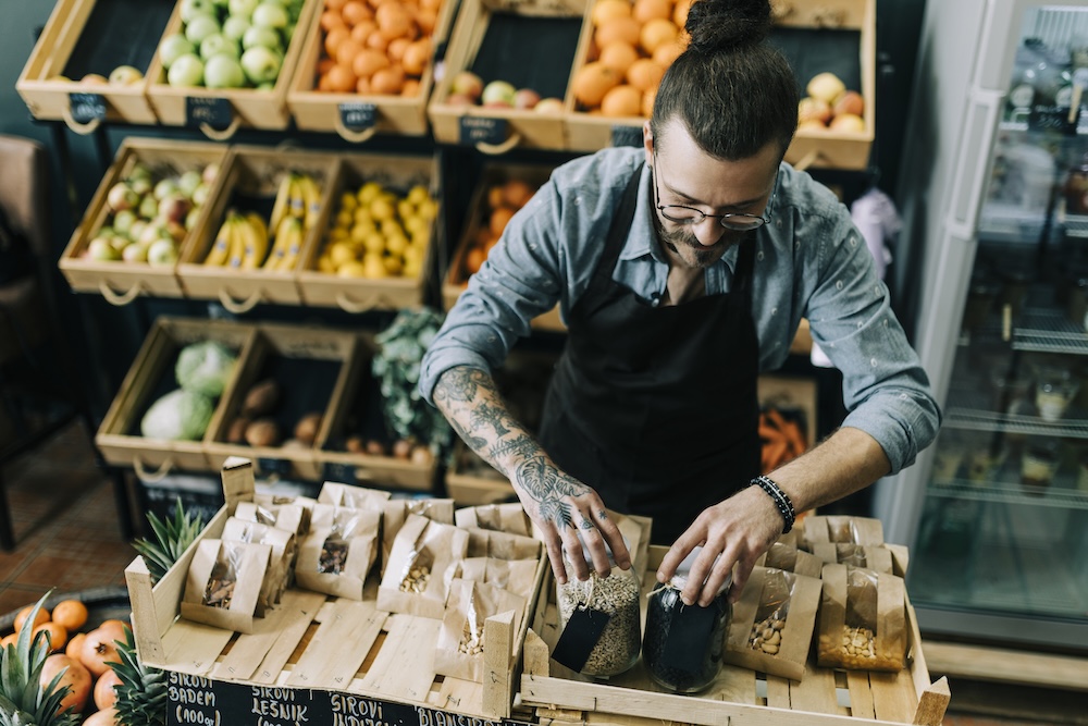 grocery store employee stocking granola and hiking snacks