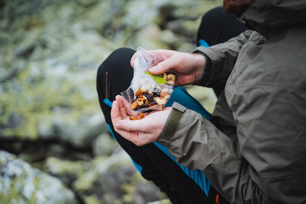 person eating trail mix on a hike