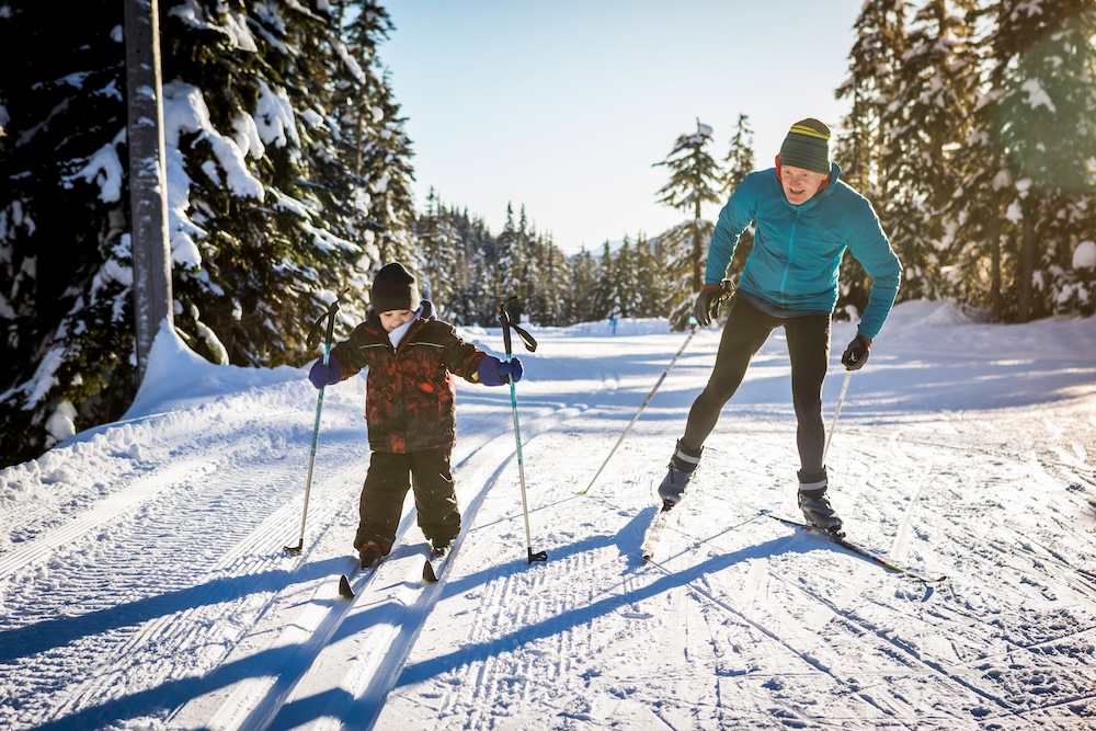 father teaching little boy how to cross country ski