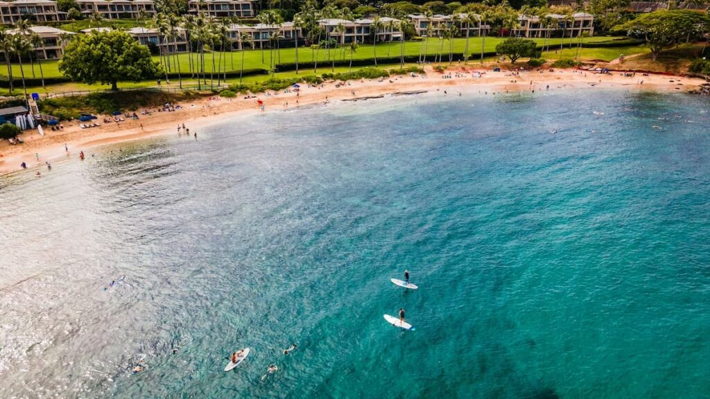 People stand-up paddleboarding at Kapalua Bay on Maui which is a great for people visiting Maui on a budget