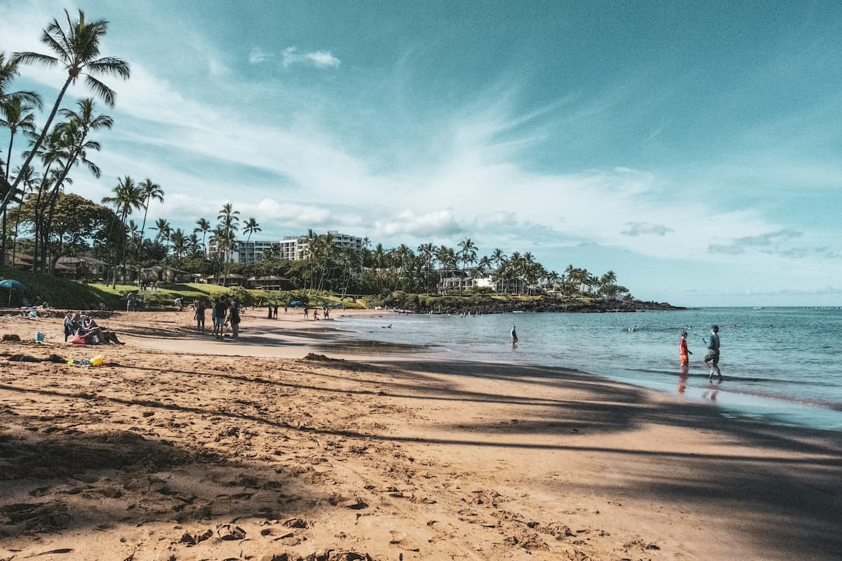 People walking along Wailea Beach which is free to visit and an affordable day out on Maui