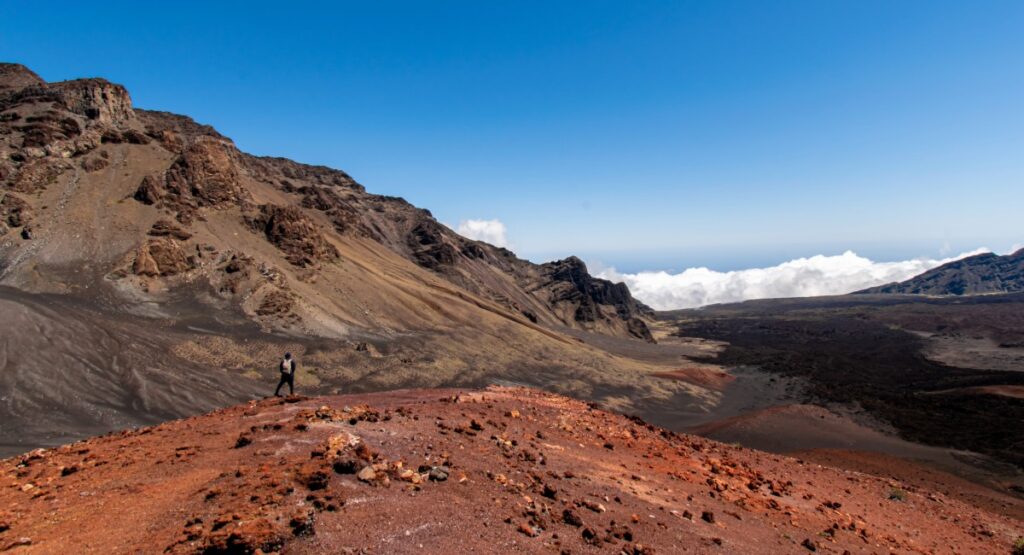 Volcanic landscape inside Haleakalā Crater with silversword plants and colorful rocky terrain under a clear blue sky on Maui