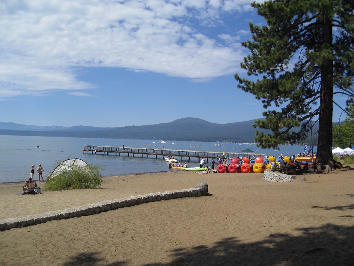 Shoreline of Kings Beach with jetty and mountain range in background