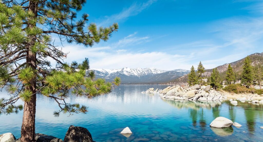 Lake Tahoe Sand Harbor on a clear day with Sierra Nevada mountains covered with snow in the background